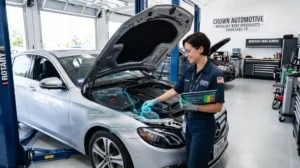 A certified technician performing a comprehensive multi-point inspection on a Mercedes-Benz sedan at a Sugar Land, TX repair shop
